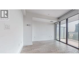 A spacious room with a sliding glass door leading to a balcony.