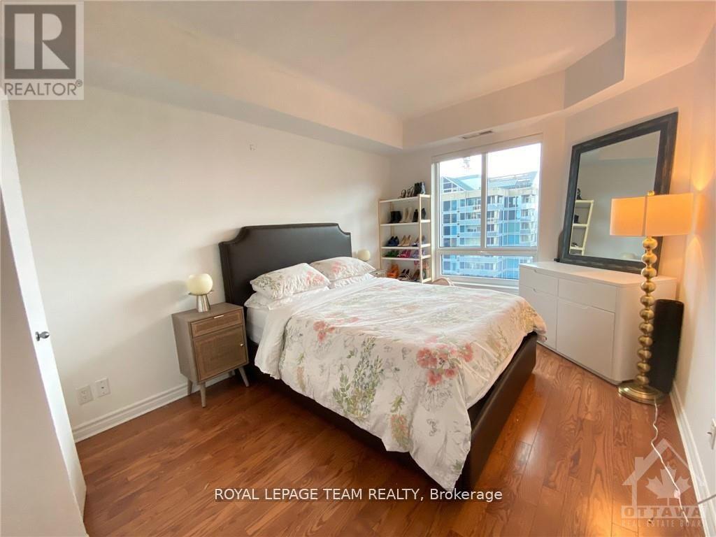 A bedroom with a bed, nightstand, and lamp.