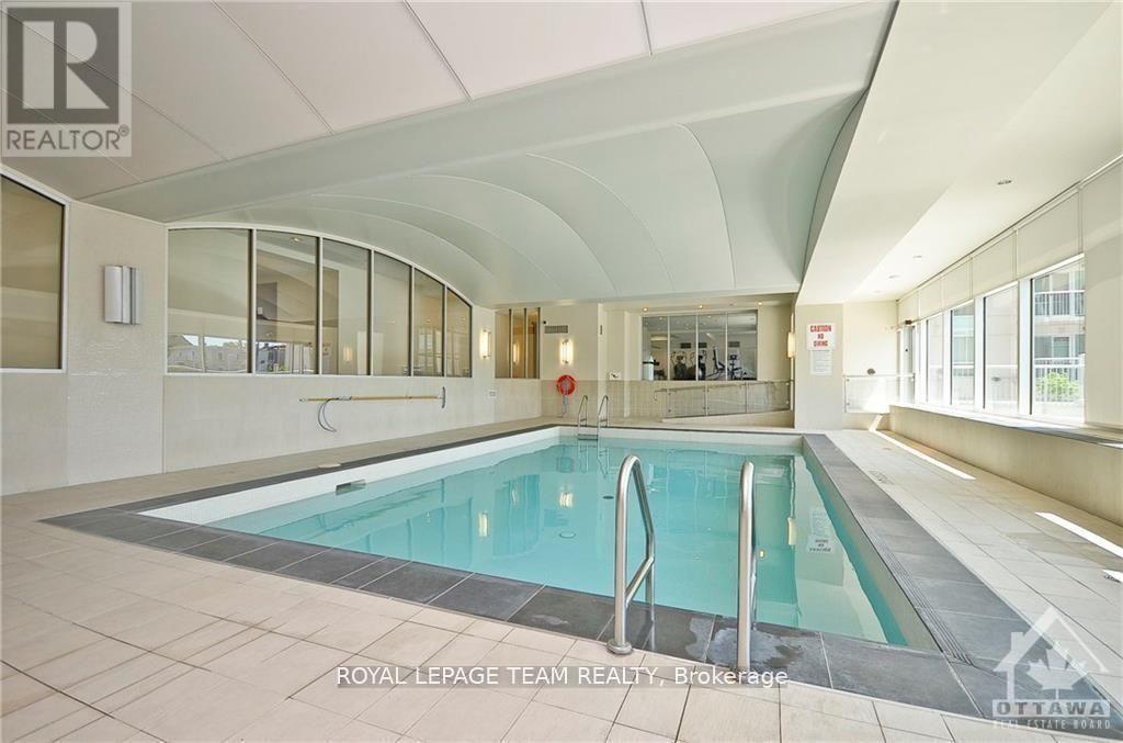 A large indoor swimming pool with a glass wall on one side.