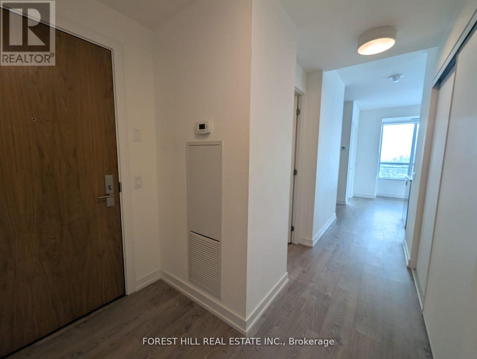 A hallway with a wooden door and a white wall.