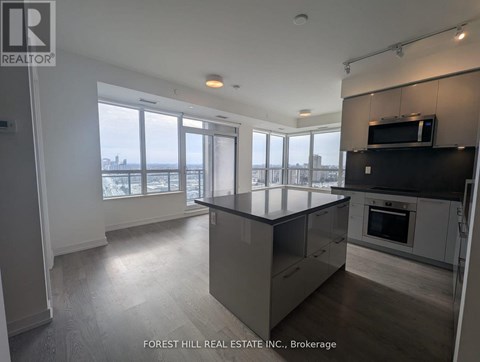 A modern kitchen with a large island and a view of the city.