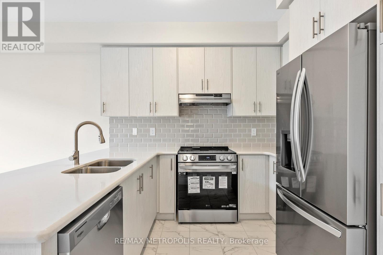 A kitchen with a stove top oven and a refrigerator.