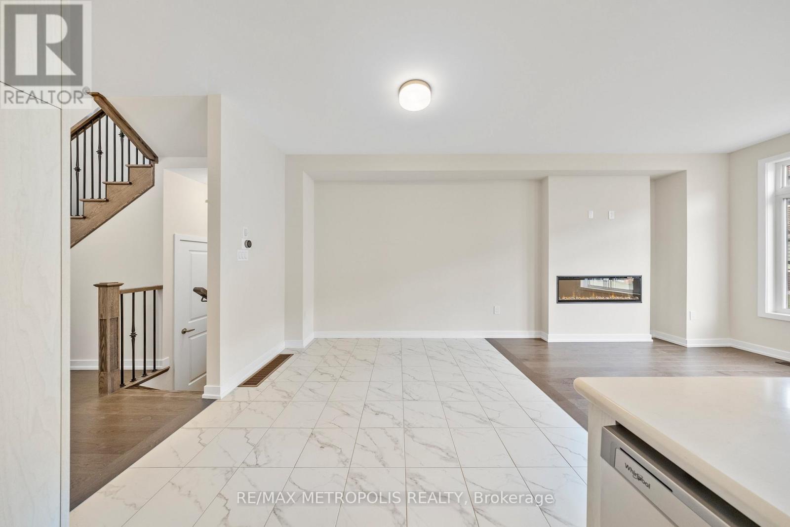 A spacious bedroom with a large bed and a staircase on the left side.