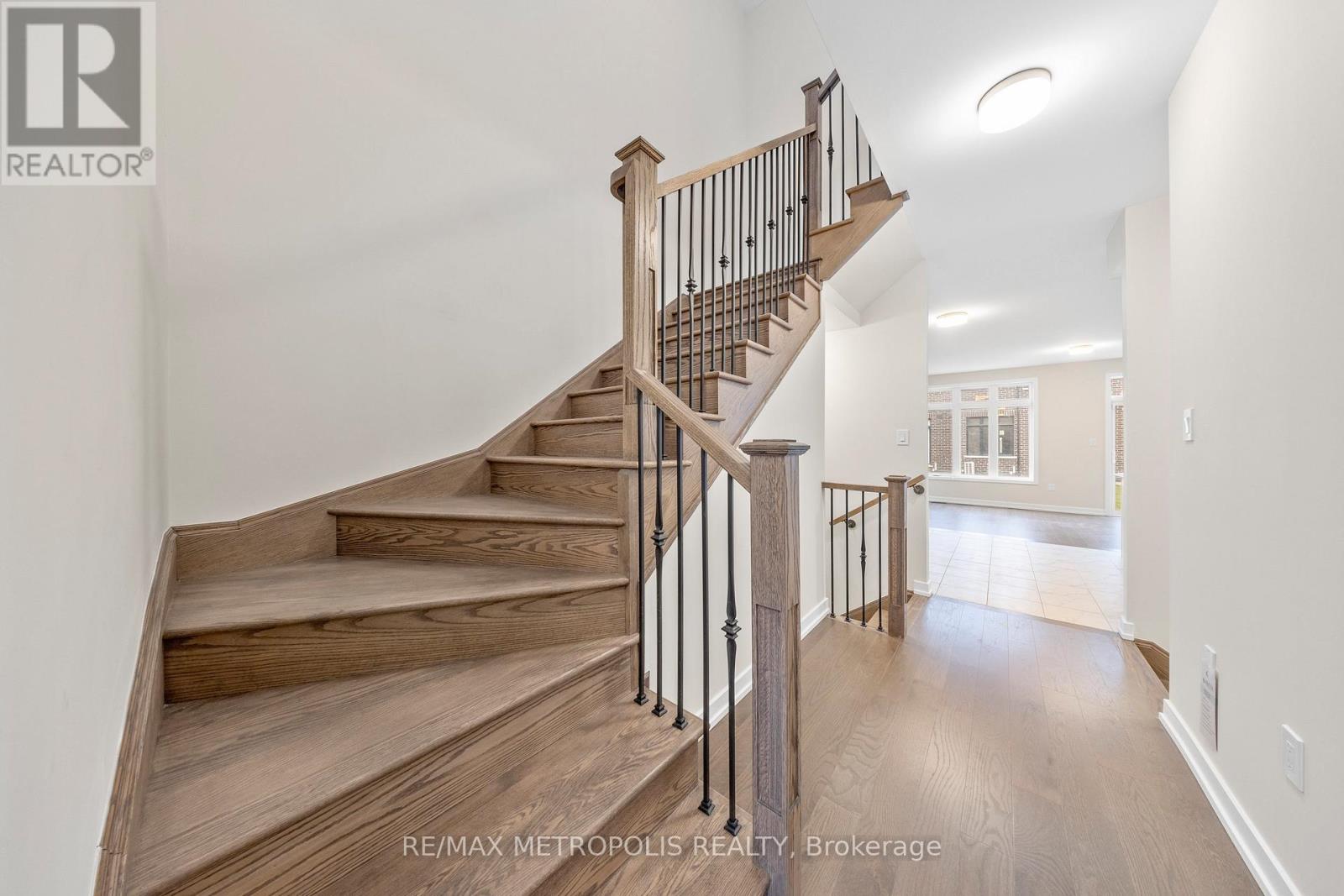 A wooden staircase with a metal railing in a spacious room.