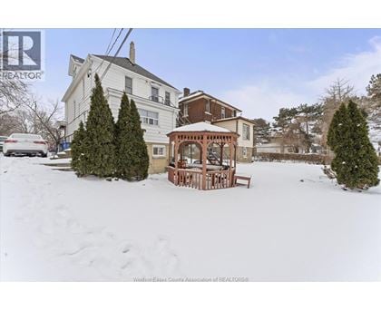 A house with a snow-covered front yard and a gazebo.