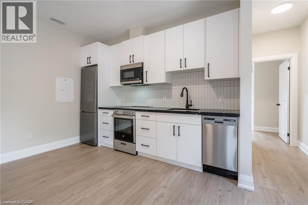 A kitchen with white cabinets and stainless steel appliances.