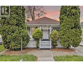 A house with a front yard and a tree in front of it.