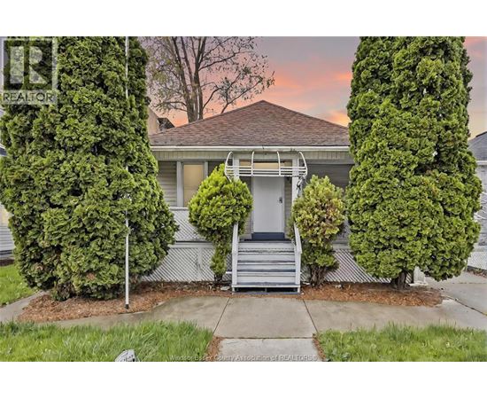 A house with a front yard and a tree in front of it.