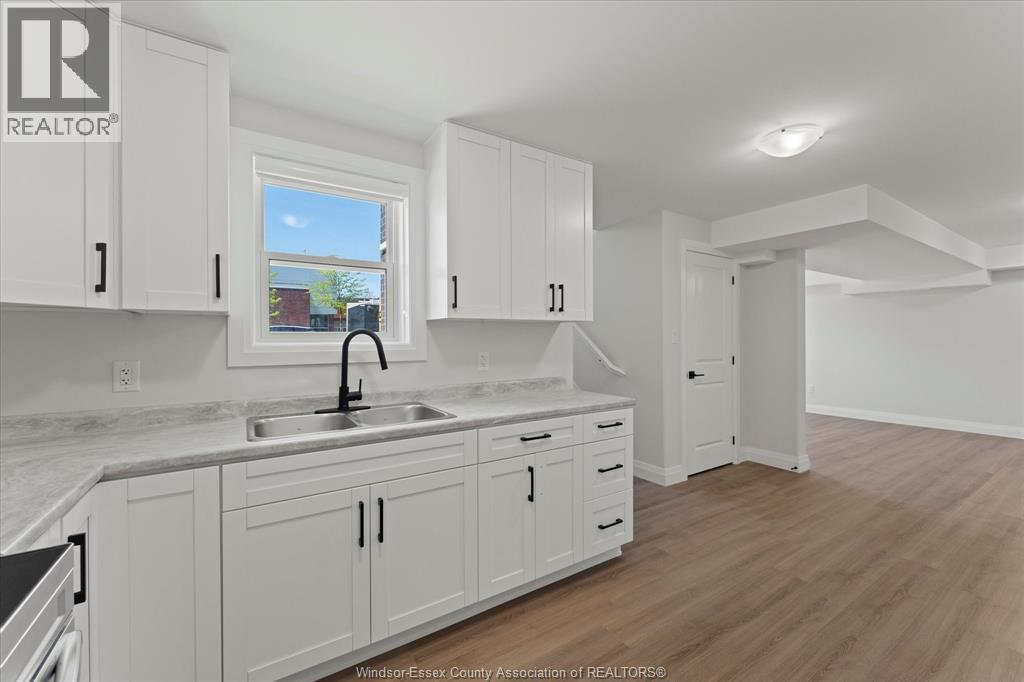 A kitchen with white cabinets and a marble countertop.