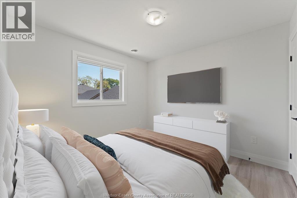 A bedroom with a large bed and a flat screen TV mounted on the wall.
