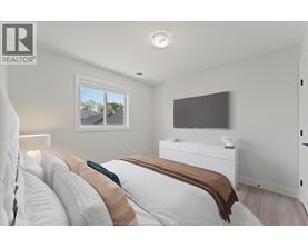 A bedroom with a large bed and a flat screen TV mounted on the wall.