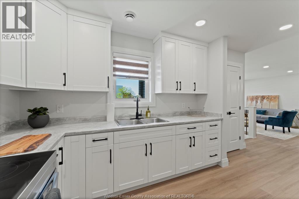 A kitchen with white cabinets and a marble countertop.