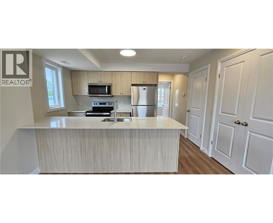 A kitchen with a white counter top and wooden cabinets.