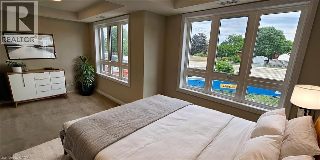 A bedroom with a large bed and a window overlooking a pool.