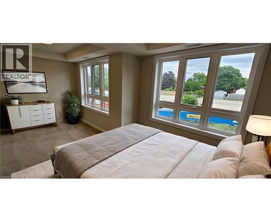 A bedroom with a large bed and a window overlooking a pool.
