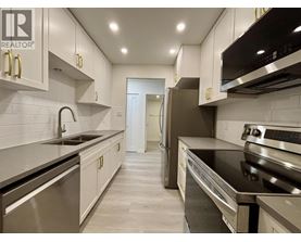 A modern kitchen with stainless steel appliances and white cabinets.