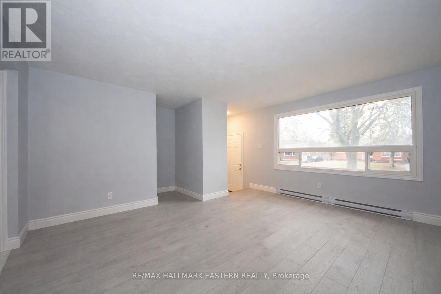 A spacious room with a window overlooking a street.