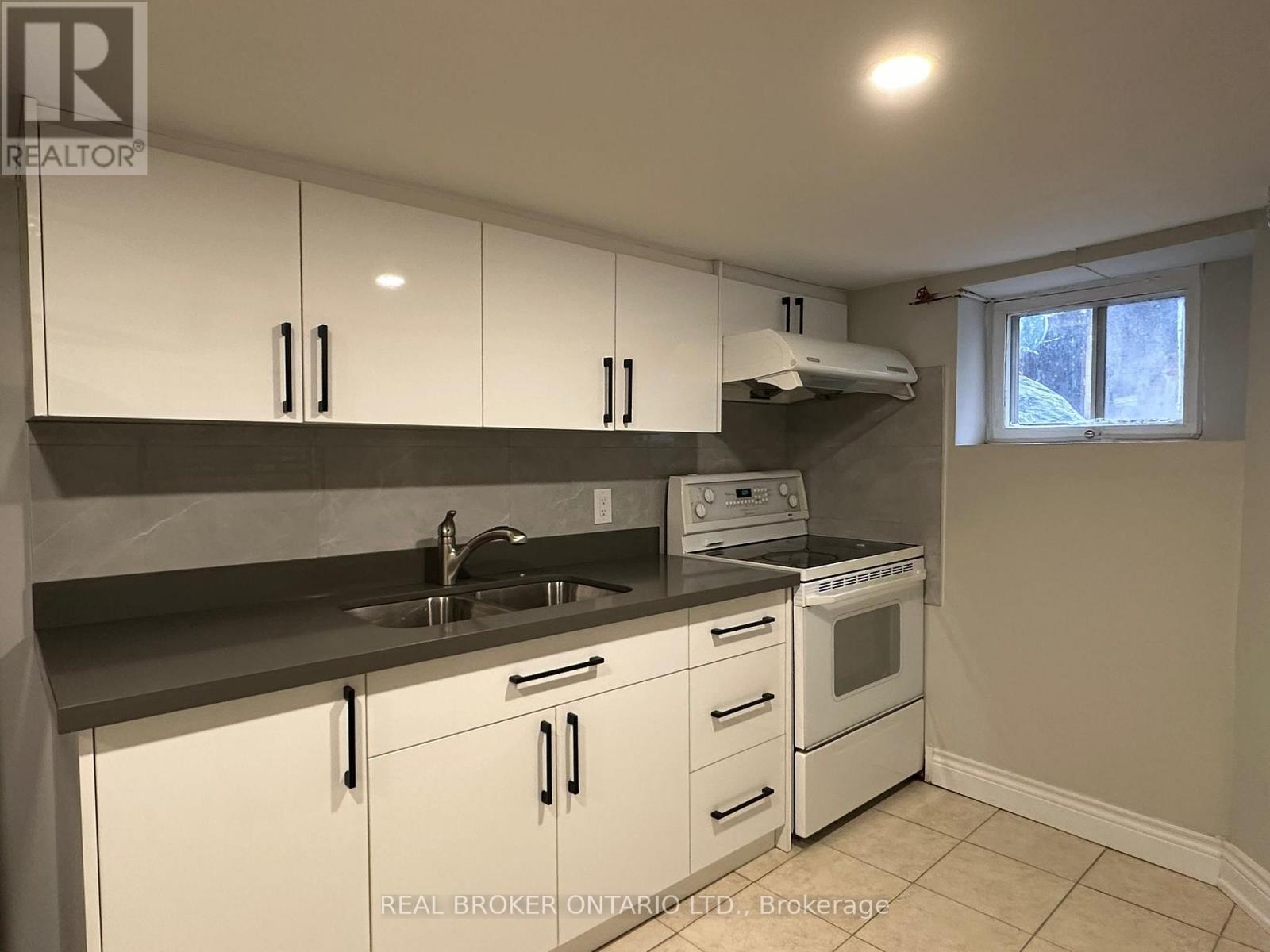A kitchen with white cabinets and a black countertop.