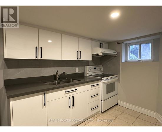 A kitchen with white cabinets and a black countertop.