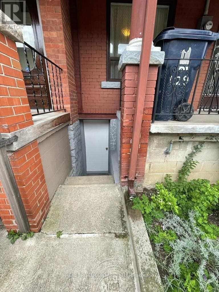 A small door is on the side of a brick building.