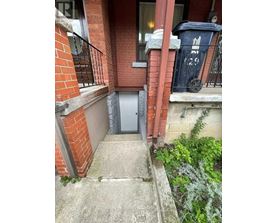 A small door is on the side of a brick building.