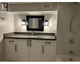 A bathroom with a sink, mirror, and cabinets.