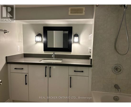 A bathroom with a sink, mirror, and cabinets.