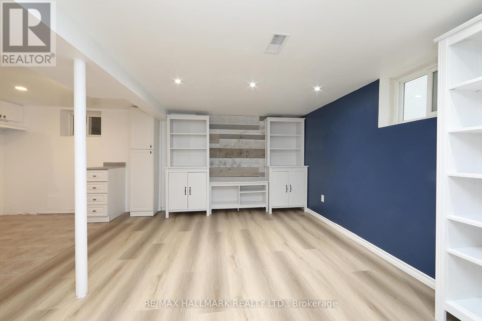 A spacious room with white furniture and a blue wall.