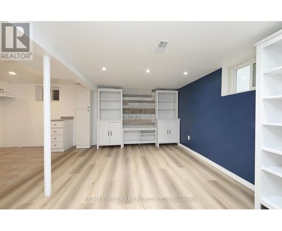 A spacious room with white furniture and a blue wall.