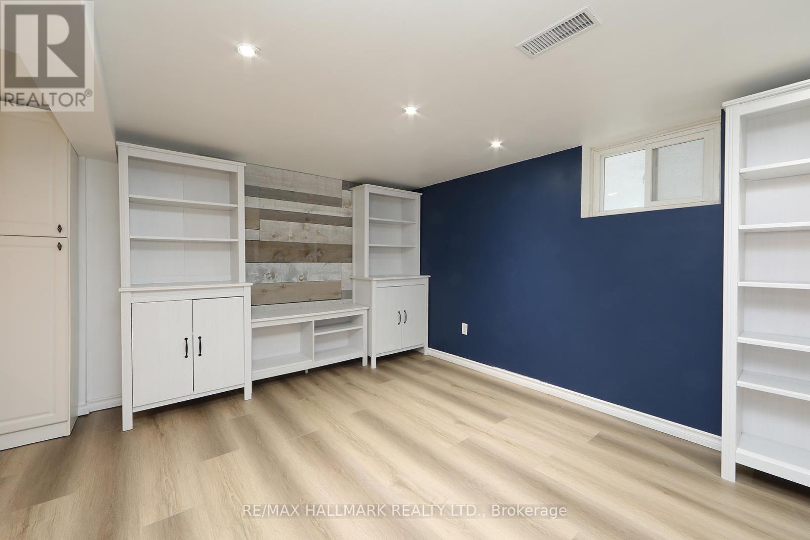 A room with white shelves and cabinets against a blue wall.