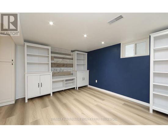 A room with white shelves and cabinets against a blue wall.
