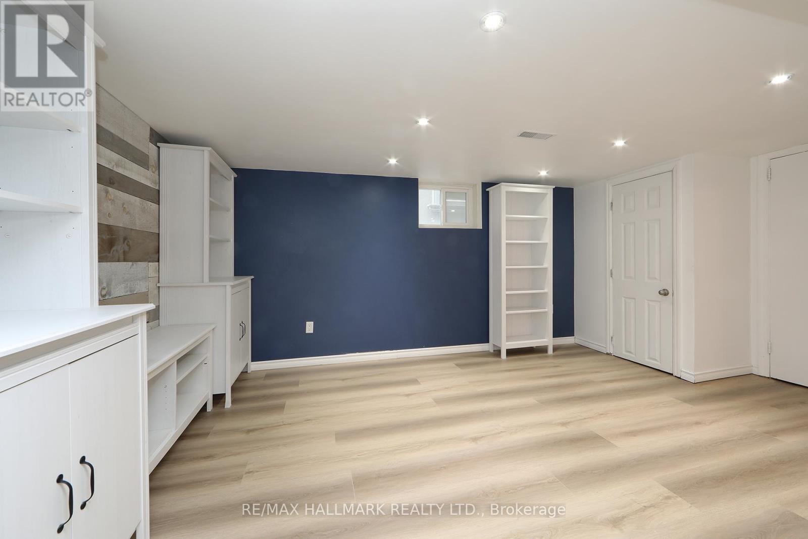 A spacious room with white furniture and a ladder against the wall.