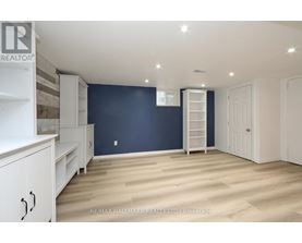 A spacious room with white furniture and a ladder against the wall.