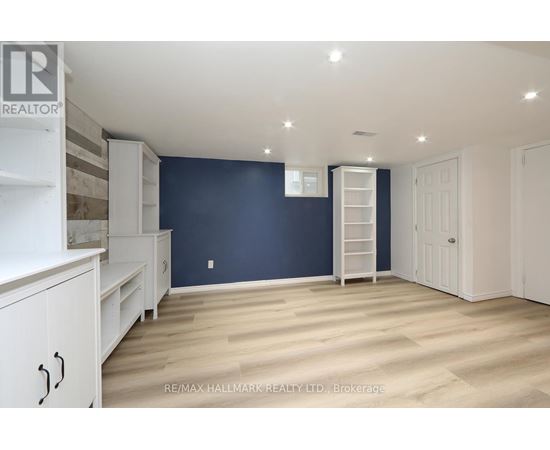A spacious room with white furniture and a ladder against the wall.