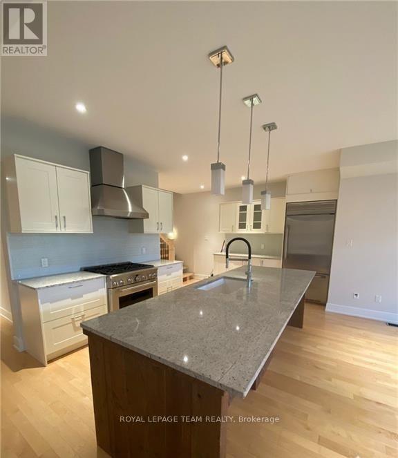 A modern kitchen with a granite countertop and stainless steel appliances.