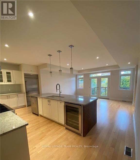 A modern kitchen with wooden floors and a large island.