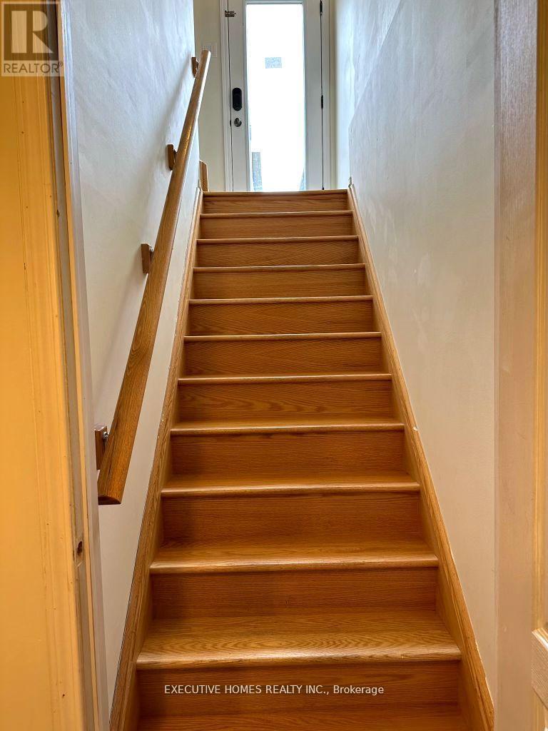 A wooden staircase with a white wall on the side.