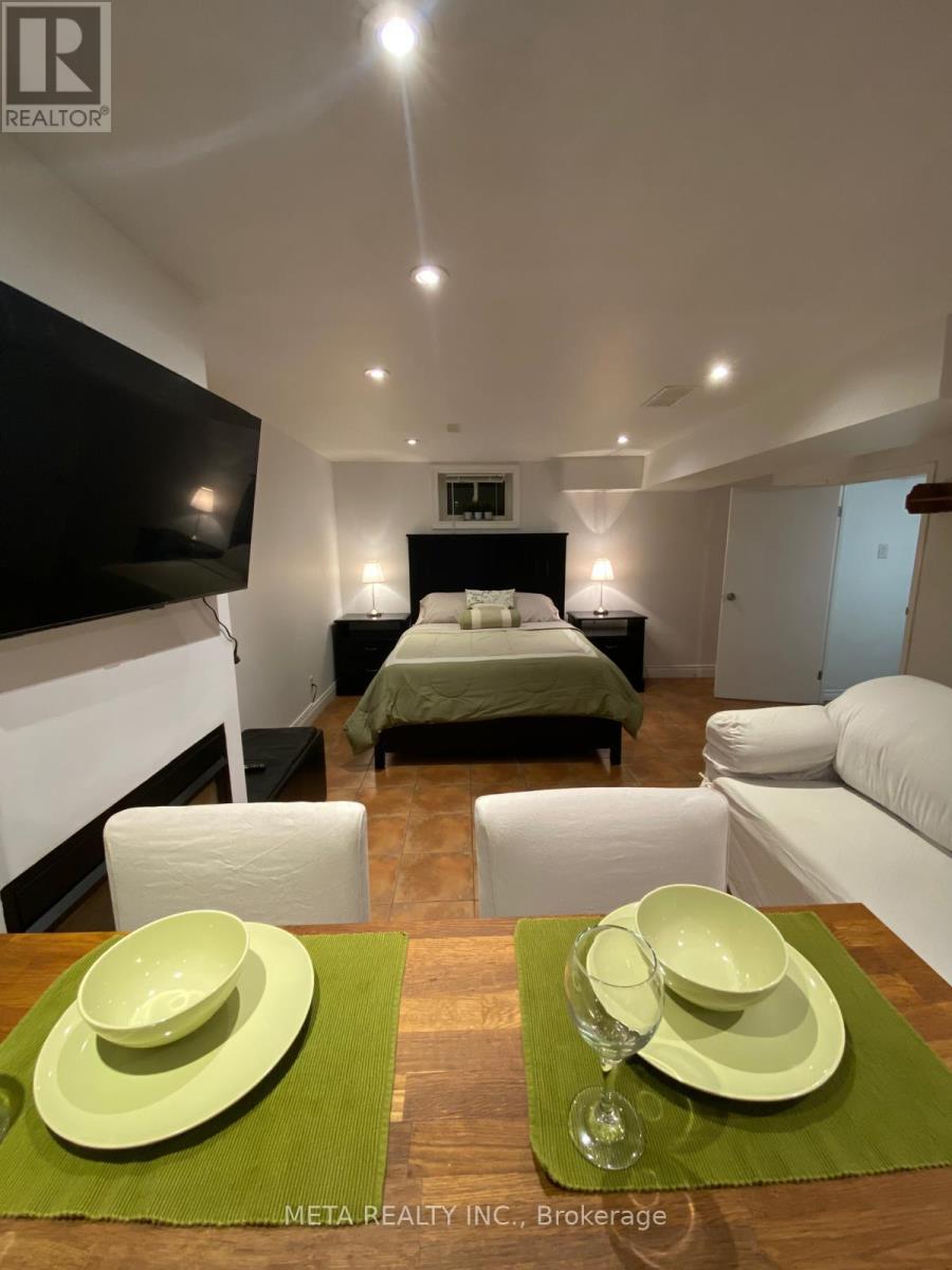 A modern bedroom with a bed, couch, and television.