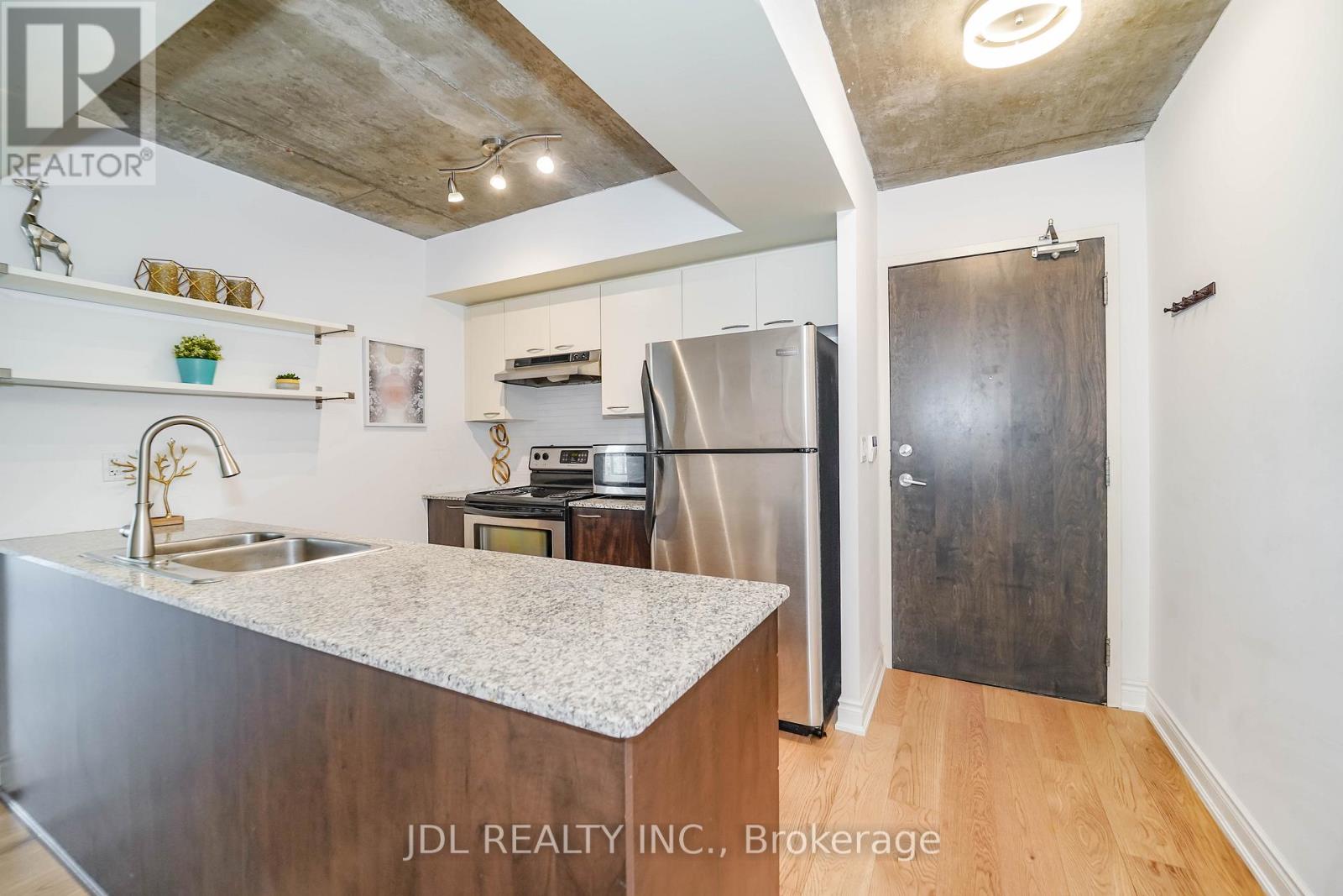 A kitchen with a marble countertop and stainless steel appliances.