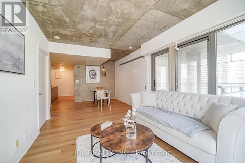 A living room with a white couch and a wooden coffee table.