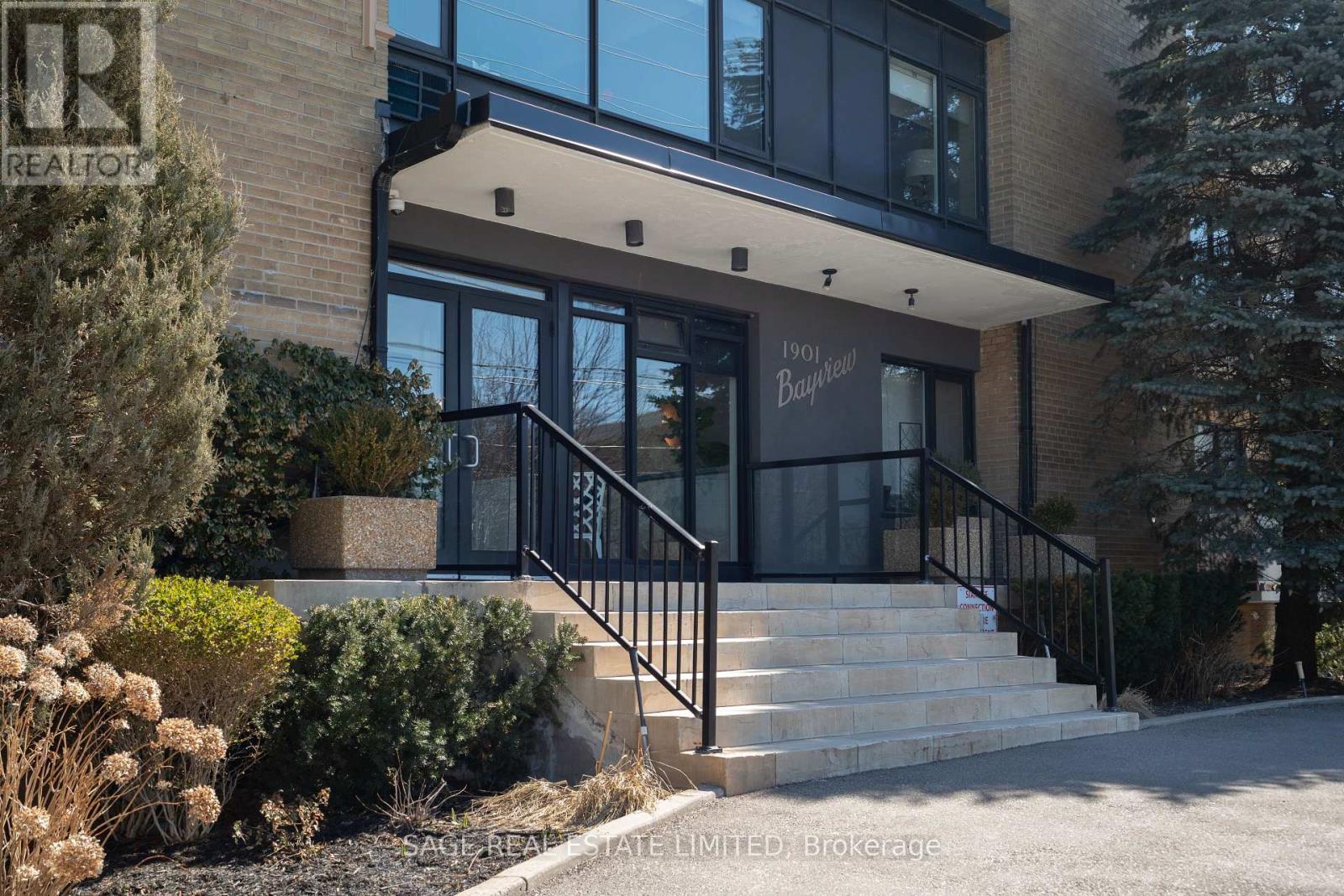 A modern house with a glass entrance and a staircase leading to the door.