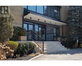 A modern house with a glass entrance and a staircase leading to the door.