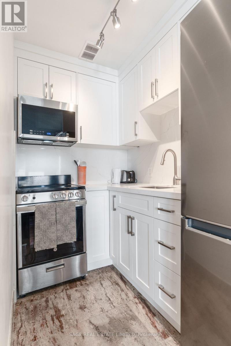 A modern kitchen with white cabinets and stainless steel appliances.