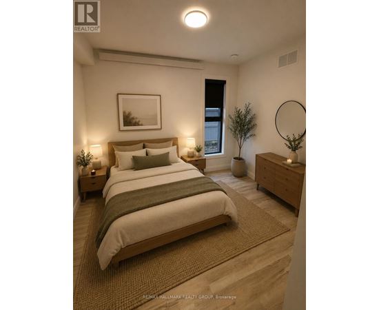 A bedroom with a large bed, a nightstand, and a plant.
