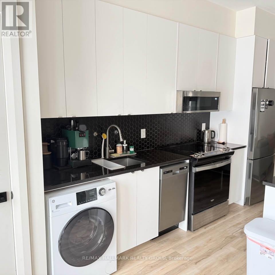 A modern kitchen with a washing machine and a refrigerator.