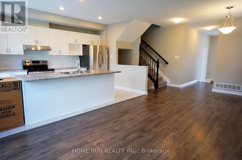 A kitchen with wooden floors and white cabinets.