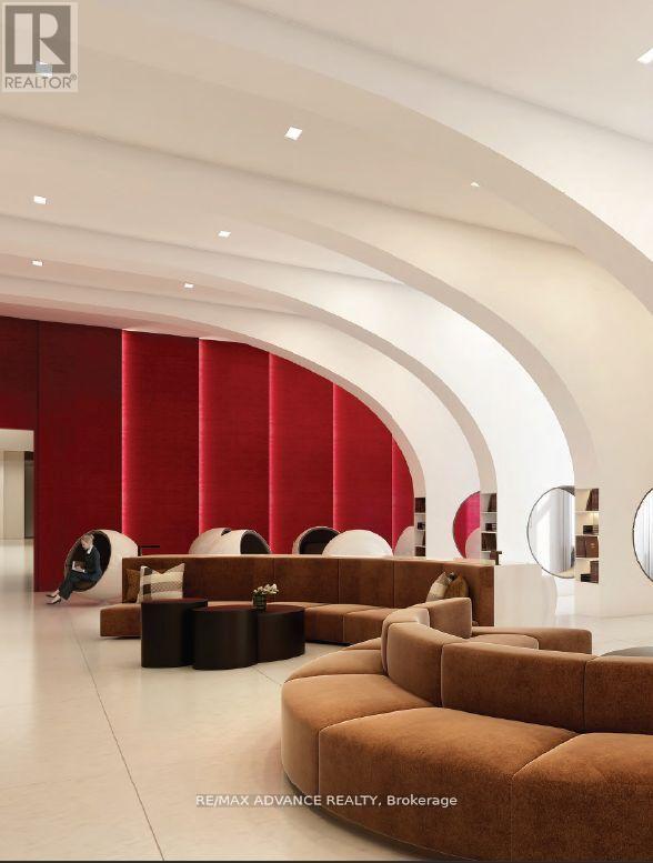 A modern living room with a curved wall and a person sitting on a chair.
