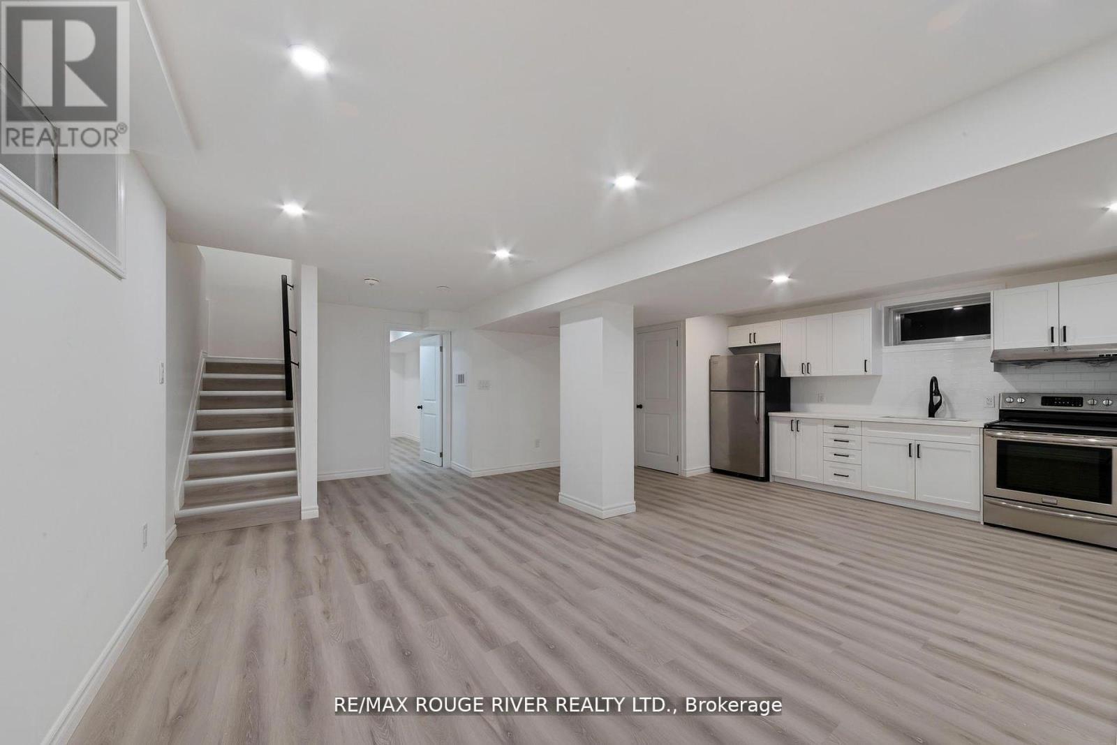 A spacious kitchen with white cabinets and stainless steel appliances.