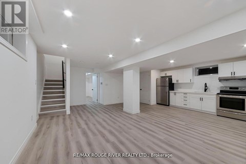 A spacious kitchen with white cabinets and stainless steel appliances.