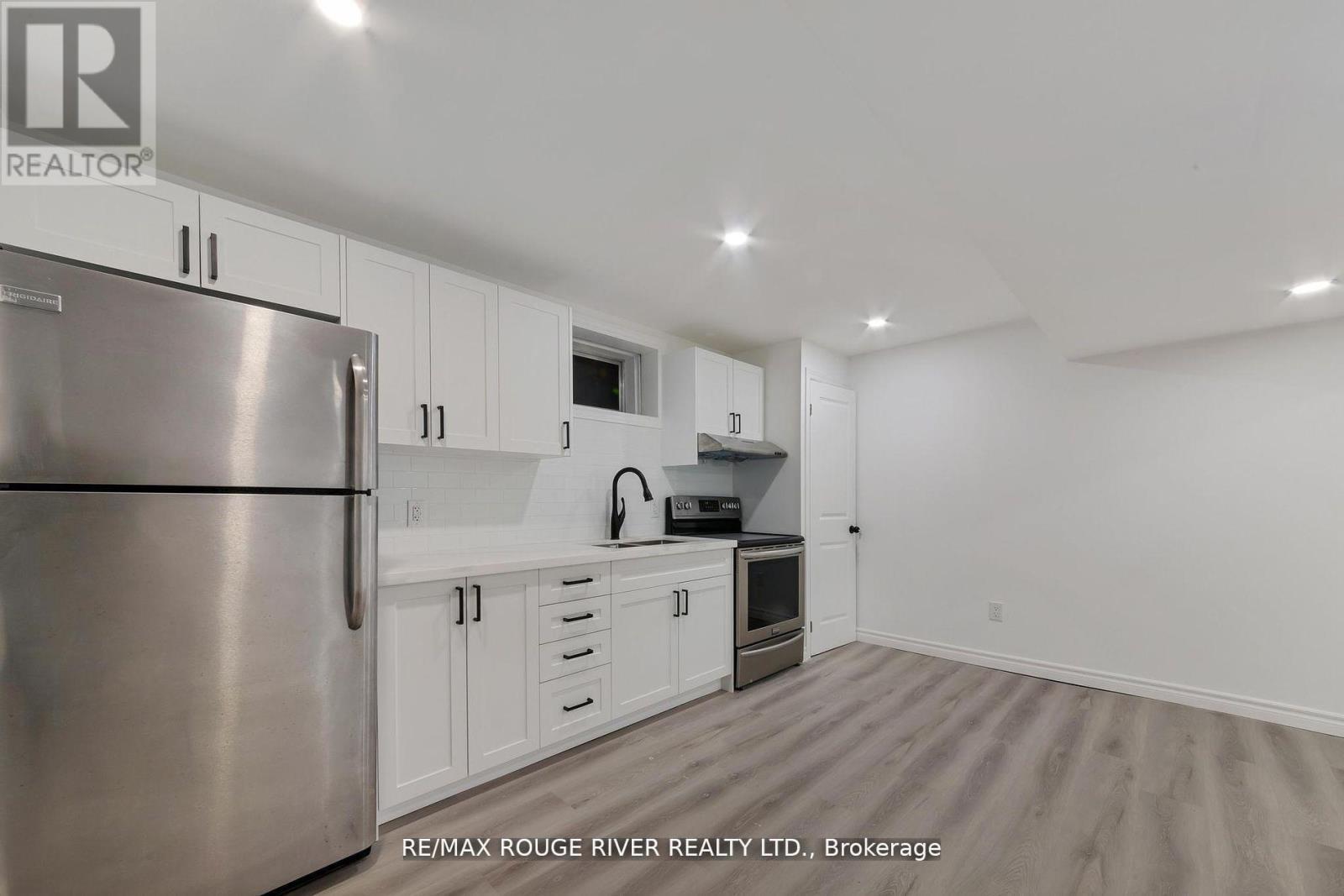 A kitchen with white cabinets and a stainless steel refrigerator.